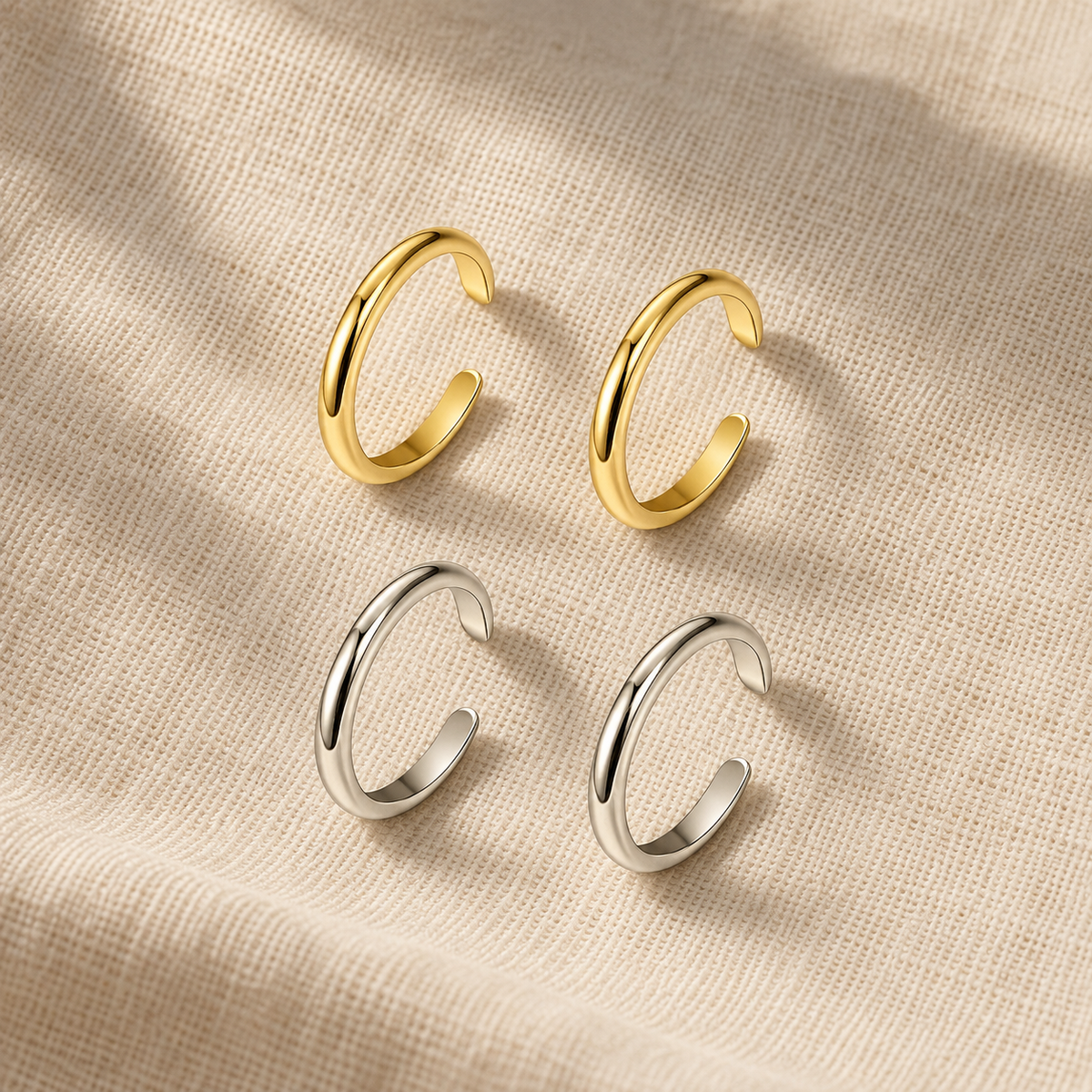 Two-piece adjustable toe rings shown in gold and steel finishes on linen