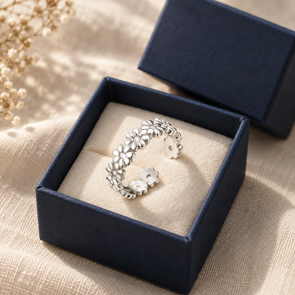 Sterling silver daisy-chain toe ring in an open navy gift box