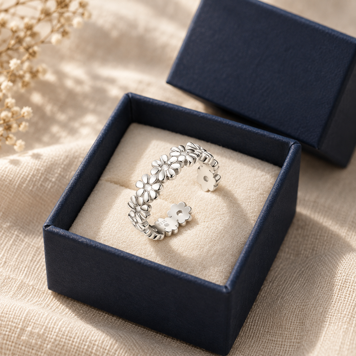 Sterling silver daisy-chain toe ring in an open navy gift box
