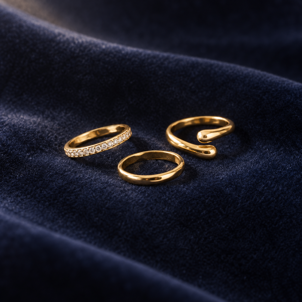 CZ toe ring trio on deep navy velvet: a crystal band, a plain band and an open band with rounded ends